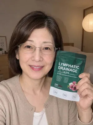 Smiling woman with glasses holding a pack of Zeelar softgels in her bedroom