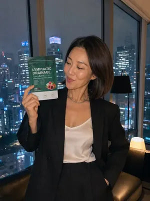 Woman with a dark bob holding up a pack of Zeelar softgels at home in the evening