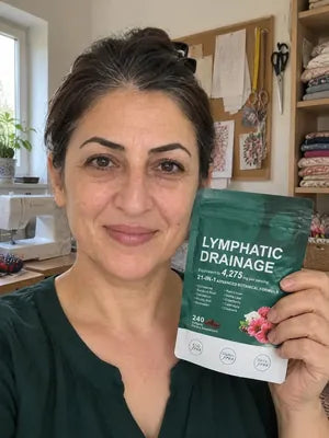 Smiling woman with dark hair holding a pack of Zeelar softgels in her sewing room