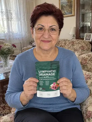 Smiling woman with glasses holding a pack of Zeelar softgels on her sofa